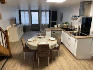 a kitchen and dining room with a table and chairs at La Har'Elle in Château-Gontier
