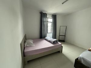 małe łóżko w pokoju z oknem w obiekcie 2-bedroom Apartment in Rose-Hill w mieście Trianon