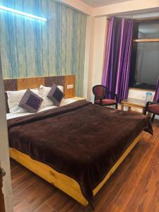 Asha Residency Shimla - Airport Road في شيملا: غرفة نوم بسرير كبير في غرفة