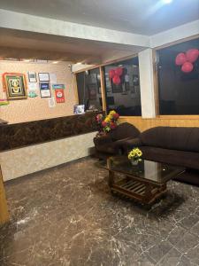 Asha Residency Shimla - Airport Road في شيملا: غرفة معيشة مع أريكة وطاولة