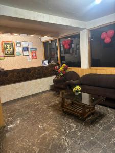 a living room with a couch and a table at Asha Residency Shimla - Airport Road in Shimla