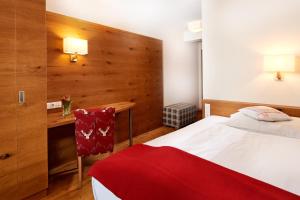 ein Hotelzimmer mit einem Bett und einem Schreibtisch in der Unterkunft Hotel Kerschbaumer in Russbach am Pass Gschütt