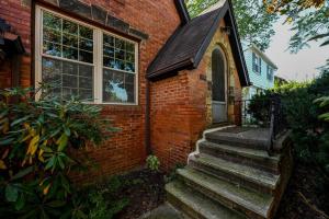 ein Backsteinhaus mit einer Treppe, die zu einer Tür führt in der Unterkunft SuperHost PLUS ~ Designer Inspired Boynton Bungalow in Cleveland Heights