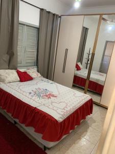 - une chambre avec un lit et un miroir dans l'établissement Recanto Caiçara, à Solemar