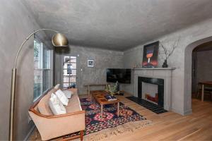 ein Wohnzimmer mit einem Sofa und einem Kamin in der Unterkunft SuperHost PLUS ~ Designer Inspired Boynton Bungalow in Cleveland Heights