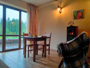 a dining room with a table and a wood stove at Рудий Лис in Skhidnitsa