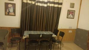 una mesa y sillas en una habitación con cortina en Zaranka Camps, en Hisār