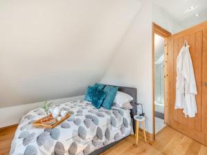 a bedroom with a large bed with blue pillows at Three Gables in Kirklington