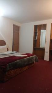een hotelkamer met een bed met een rode deken bij Zaranka Camps in Hisār