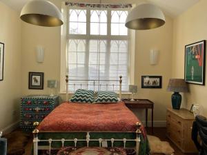 a bedroom with a bed and a large window at Charming Old Schoolroom Studio in Daventry