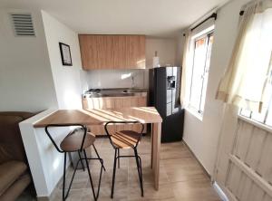 eine kleine Küche mit einem Holztisch und 2 Stühlen in der Unterkunft Aparta Estudio nuevo a 2 calles de Milán in Manizales