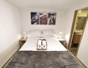 ein Schlafzimmer mit einem Bett mit zwei Schuhen drauf in der Unterkunft Aparta Estudio nuevo a 2 calles de Milán in Manizales