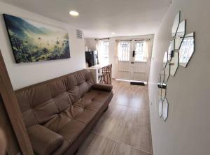 ein Wohnzimmer mit einem Sofa und einer Küche in der Unterkunft Aparta Estudio nuevo a 2 calles de Milán in Manizales