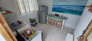 einen Blick über eine Küche mit einem Tisch und einem Kühlschrank in der Unterkunft Apartamento Los Blancos, a dos Minutos de los Patos Barahona in Enriquillo