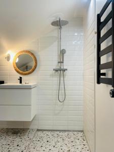 a white bathroom with a shower and a sink at Amber bay in Juodkrantė