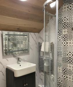 a bathroom with a sink and a shower at Craster Coastal Cabins in Craster