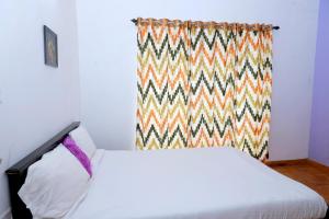 um quarto com uma cama com uma cortina colorida em Seven Endue Elite em Ooty