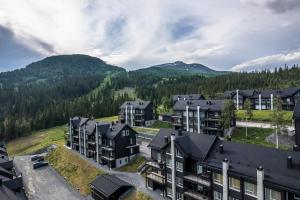 an aerial view of an apartment complex with mountains in the background at Åre Valley Lodges - Ytterstmyrvägen 19D in Åre
