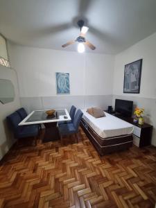 a bedroom with a bed and a table in it at Comodidade e Segurança no Centro in Belo Horizonte