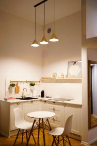 a kitchen with white cabinets and a table and chairs at Art Apartment Bydgoszcz in Bydgoszcz