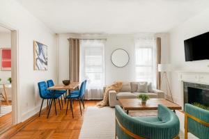 a living room with a couch and a table and chairs at 61-2C Prime UES 2BR Newly furnished best value in New York