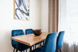 a dining room table with blue chairs and a bowl on top at 61-2C Prime UES 2BR Newly furnished best value in New York