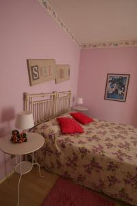 - une chambre avec un lit doté d'oreillers rouges et d'une table dans l'établissement B&B Il Nido Di Alice, à Moresco