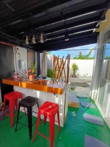 Bmf Homestay Jacuzzi في تاكلوبان: مطبخ مع اثنين من الكراسي الحمراء ومكتب