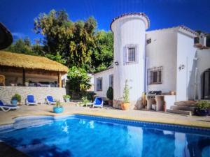 una casa con piscina frente a ella en Villa ARMONIA, en Benissa