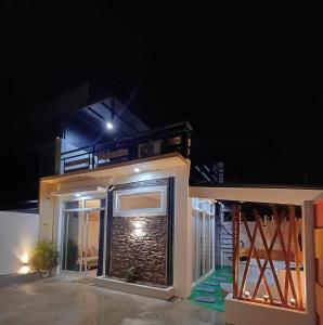 Bmf Homestay Jacuzzi في تاكلوبان: منزل صغير في الليل مع شرفة