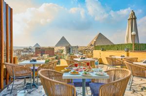 a table with food and chairs on a balcony overlooking the pyramids at Cleopatra Tower Pyramids View in Cairo