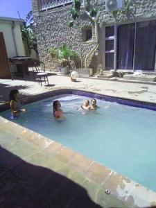 three children swimming in a swimming pool at Ochsenwagen Pension Hotel in Rehoboth