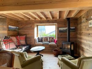 a living room with a fireplace in a log cabin at chalet en montagne in Lées-Athas