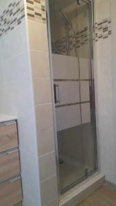 La salle de bains est pourvue d'une douche et d'une porte en verre. dans l'établissement Résidence Gavarnie appart RDC, à Gèdre