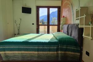 a bedroom with a bed with a view of a window at Casa Vignolet : la finestra su Pont-Saint-Martin in Pont-Saint-Martin