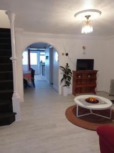 a living room with a table and a tv at Shepherds Spacious House 4-Beds in Romford