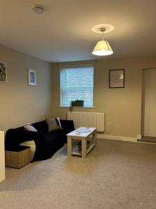 Well Equipped Apartment In Stoke on Trent في ستوك أون ترينت: غرفة معيشة مع أريكة وطاولة