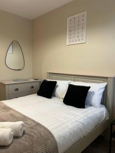 a bedroom with a white bed with black pillows at Well Equipped Apartment In Stoke on Trent in Stoke on Trent