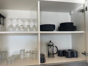 a kitchen shelf with glasses and plates on it at Luxury Appartment Belgrade Waterfront in Belgrade