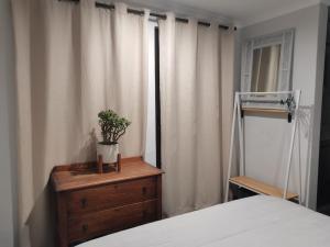 a bedroom with a bed and a dresser with a plant on it at Ruach 5 in Bellville
