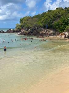 um grupo de pessoas na água em uma praia em Pousada Vento Norte em São Miguel do Gostoso