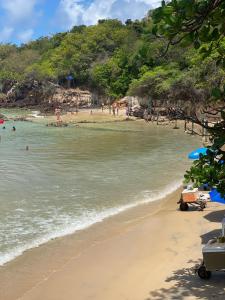 uma praia com um grupo de pessoas na água em Pousada Vento Norte em São Miguel do Gostoso