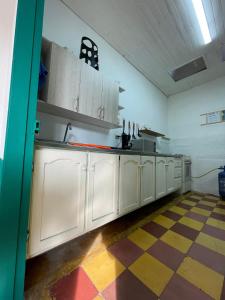 a kitchen with white cabinets and a checkered floor at Origen Hostel Jardín in Jardin