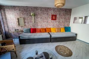 a large bed in a room with a brick wall at Double Appart Hypercentre Blois in Blois