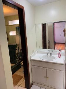 uma casa de banho com um lavatório branco e um chuveiro em Dulce Hogar 01 em Loja