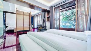 a bedroom with two beds and a window at Qingxin Courtyard Art Guesthouse in Dali