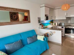 a living room with a blue couch in a kitchen at Almadrava Beach in Roses