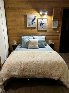 1 dormitorio con 1 cama grande y pared de madera en Côté-Bourget 3 pers LA BELLE PLINIER proche La Norma Aussois, en Villarodin-Bourget