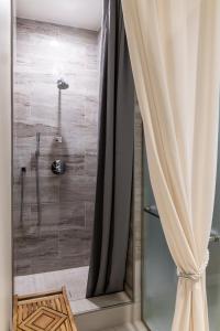 a shower with a glass door and a curtain at Sheraton Flowood The Refuge Hotel & Conference Center in Flowood