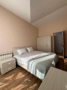 a bedroom with a large bed and a table at Diamond Bakuriani A6 in Bakuriani